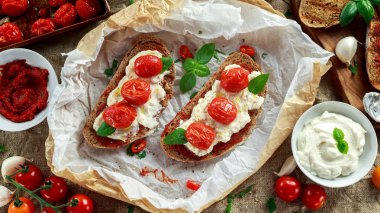 Domates Ricotta Bruschetta güneş ile kurutulmuş domates Yapıştır, zeytinyağı kahverengi ekmek ve fesleğen