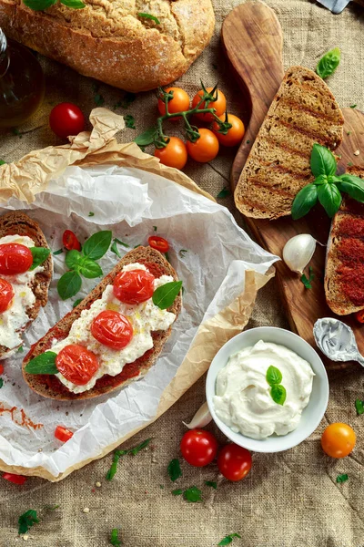 Pomidor Bruschetta Ricotta z sun suszone pomidory Wklej, chleb brązowy oliwy z oliwek i bazylii — Zdjęcie stockowe