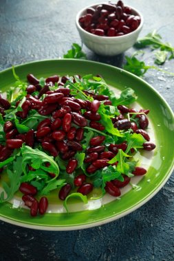Kırmızı fasulye ve yeşil bir tabak içinde vahşi roket sağlıklı salata