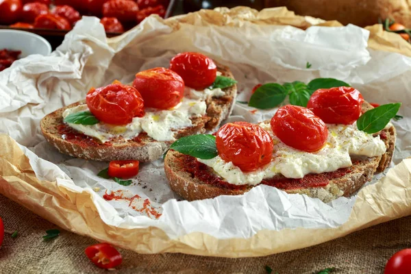 Tomate Ricotta Bruschetta con pasta de tomates secados al sol, aceite de oliva pan integral y albahaca — Foto de Stock