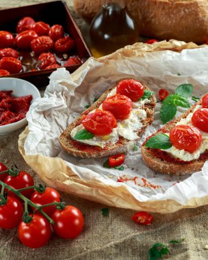 Domates Ricotta Bruschetta güneş ile kurutulmuş domates Yapıştır, zeytinyağı kahverengi ekmek ve fesleğen
