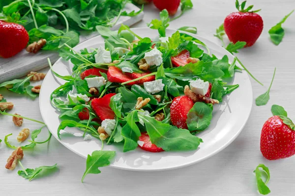 Beyaz tabakta roka ile taze çilek salatası