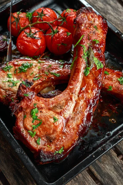 Côtelette de porc rôtie avec soupe aigre-douce, tomates cuites au four et oignon rouge — Photo