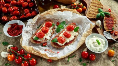 Domates Ricotta Bruschetta güneş ile kurutulmuş domates Yapıştır, zeytinyağı kahverengi ekmek ve fesleğen