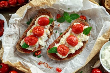 Domates Ricotta Bruschetta güneş ile kurutulmuş domates Yapıştır, zeytinyağı kahverengi ekmek ve fesleğen