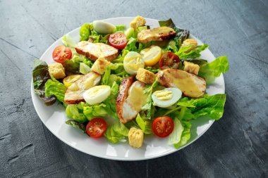 Taze sağlıklı Sezar salata tavuk, yumurta bıldırcın, domates, peynir ve Croutons beyaz bir tabak içinde