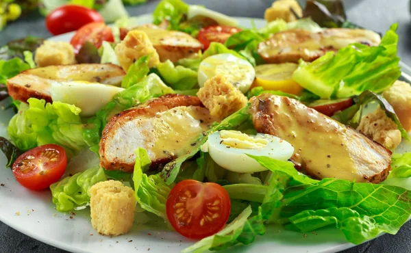 Ensalada César fresca y saludable con pollo, codorniz de huevo, tomates, queso y croutons en un plato blanco —  Fotos de Stock