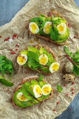 Sağlıklı avokado ve Bıldırcın yumurta tost vahşi roket ve deniz tuzu ile