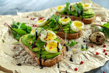 Sağlıklı avokado ve Bıldırcın yumurta tost vahşi roket ve deniz tuzu ile