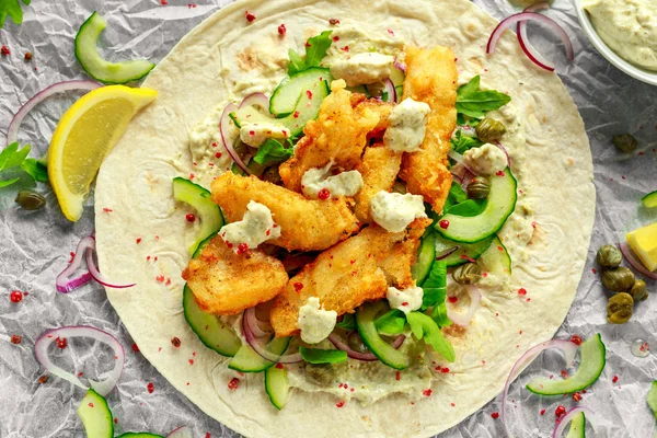 Taze balık Tortilla salatalık, kırmızı soğan, Kapari, limon, salata yaprakları ve çiğ sos ile. Sağlıklı gıda