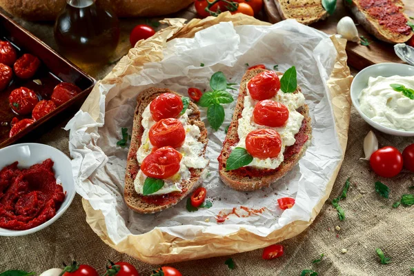 Pomidor Bruschetta Ricotta z sun suszone pomidory Wklej, chleb brązowy oliwy z oliwek i bazylii — Zdjęcie stockowe