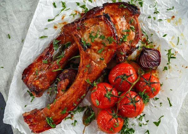 Côtelette de porc rôtie avec soupe aigre-douce, tomates cuites au four et oignon rouge — Photo