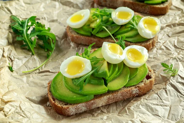 stock image Healthy Avocado and quail eggs toasts with wild rocket and sea salt