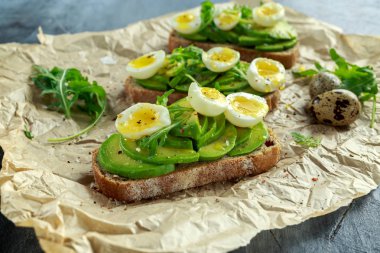 Sağlıklı avokado ve Bıldırcın yumurta tost vahşi roket ve deniz tuzu ile