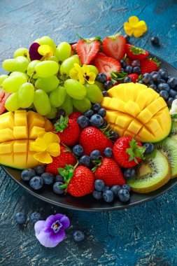 Mango, çilek, yaban mersini, kivi ve Yeşil üzüm ile renkli karışık meyve tabağı. Sağlıklı gıda