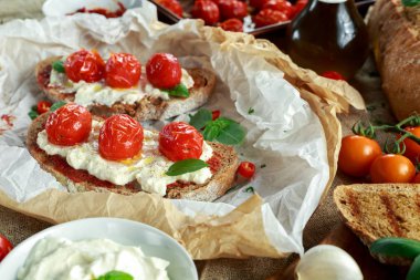 Domates Ricotta Bruschetta güneş ile kurutulmuş domates Yapıştır, zeytinyağı kahverengi ekmek ve fesleğen