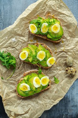 Sağlıklı avokado ve Bıldırcın yumurta tost vahşi roket ve deniz tuzu ile