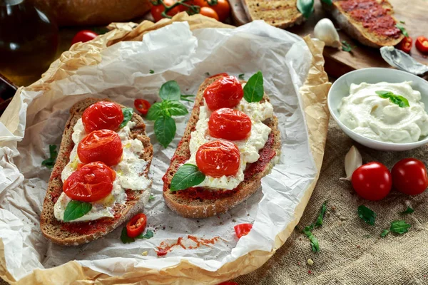 Tomate Ricotta Bruschetta con pasta de tomates secados al sol, aceite de oliva pan integral y albahaca — Foto de Stock
