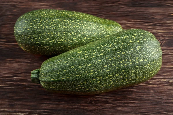 Raw Freshly picked organic marrow zucchini vegetables with leaves on wooden table — Stock Photo, Image