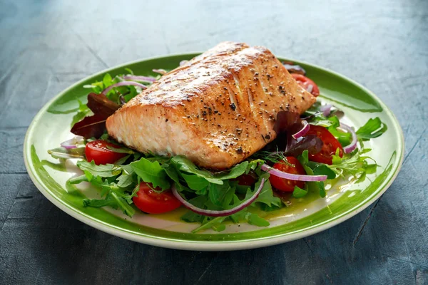 Baked salmon steak with tomato, onion, mix of green leaves salad in a plate. healthy food — Stock Photo, Image