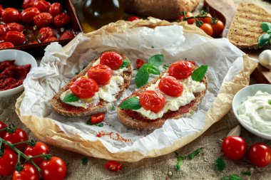 Domates Ricotta Bruschetta güneş ile kurutulmuş domates Yapıştır, zeytinyağı kahverengi ekmek ve fesleğen