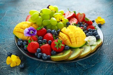 Mango, çilek, yaban mersini, kivi ve Yeşil üzüm ile renkli karışık meyve tabağı. Sağlıklı gıda