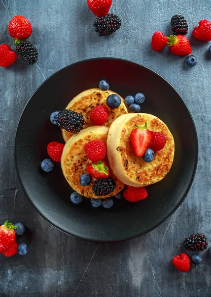 British Crumpets petit déjeuner aux myrtilles, fraises, mûres, framboises arrosées de sucre glace — Photo