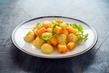 Bir tabak içinde vahşi roket ile ev yapımı Butternut kabak gnocchi