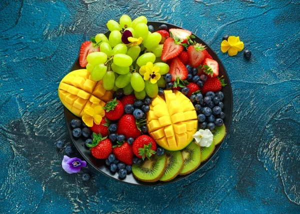 Piatto variopinto di frutta mista con mango, fragola, mirtillo, kiwi e uva verde. Cibo sano — Foto Stock