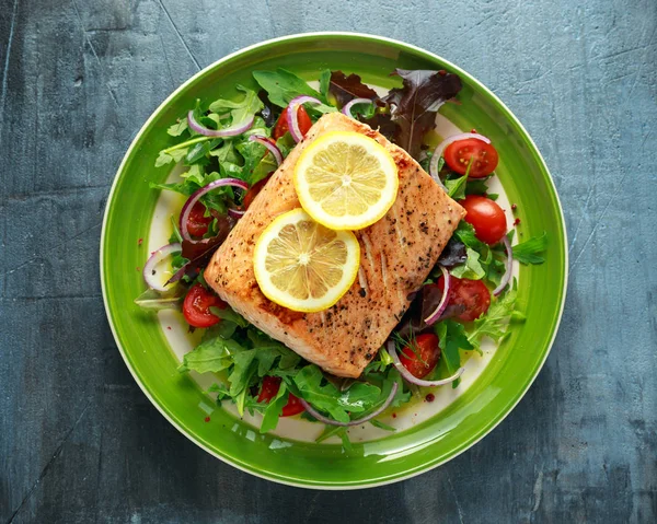 Baked salmon steak with tomato, onion, mix of green leaves salad in a plate. healthy food — Stock Photo, Image