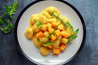 Bir tabak içinde vahşi roket ile ev yapımı Butternut kabak gnocchi
