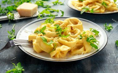 Parmesan ve plaka üzerinde vahşi roket ile mantı