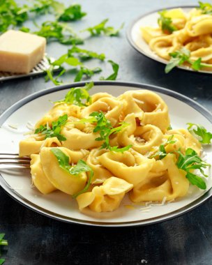 Parmesan ve plaka üzerinde vahşi roket ile mantı