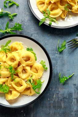 Parmesan ve plaka üzerinde vahşi roket ile mantı
