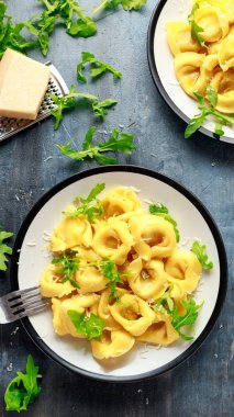 Parmesan ve plaka üzerinde vahşi roket ile mantı
