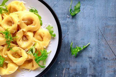 Parmesan ve plaka üzerinde vahşi roket ile mantı