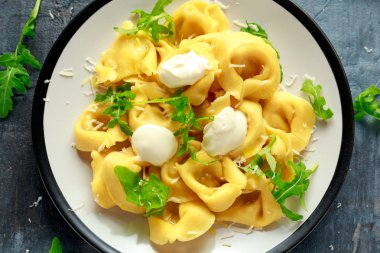 Parmesan ve plaka üzerinde vahşi roket ile mantı