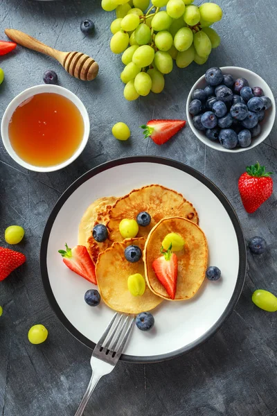 Crêpes maison aux myrtilles, fraises, raisins verts et sirop de miel. servi sur assiette — Photo