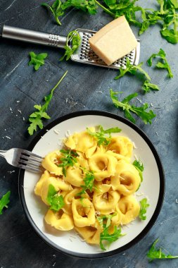 Parmesan ve plaka üzerinde vahşi roket ile mantı