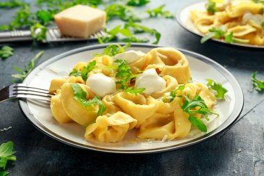 Parmesan ve plaka üzerinde vahşi roket ile mantı