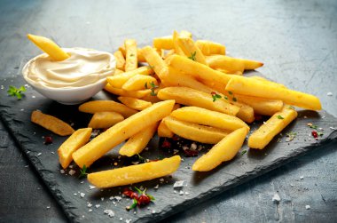 Siyah taş kurulu ev yapımı pişmiş patates kızartması mayonez, tuz, biber