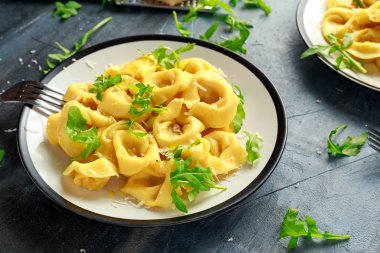 Parmesan ve plaka üzerinde vahşi roket ile mantı