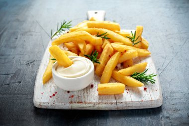 Ev yapımı pişmiş patates kızartması mayonez ve biberiye Beyaz ahşap tahta üzerinde