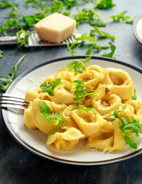 Parmesan ve plaka üzerinde vahşi roket ile mantı