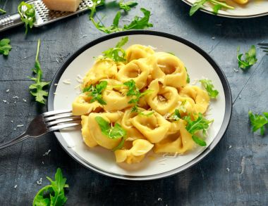 Parmesan ve plaka üzerinde vahşi roket ile mantı