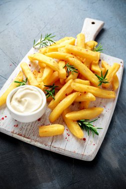 Ev yapımı pişmiş patates kızartması mayonez ve biberiye Beyaz ahşap tahta üzerinde