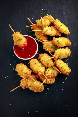 Sulu Kral keskin, altın patates küçük spiraller şiş üzerinde sarılı karides tatlı chillie sos ile servis.