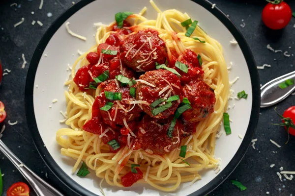 Albóndigas de pasta de espagueti con salsa de tomate, albahaca, queso parmesano de hierbas sobre fondo oscuro — Foto de Stock