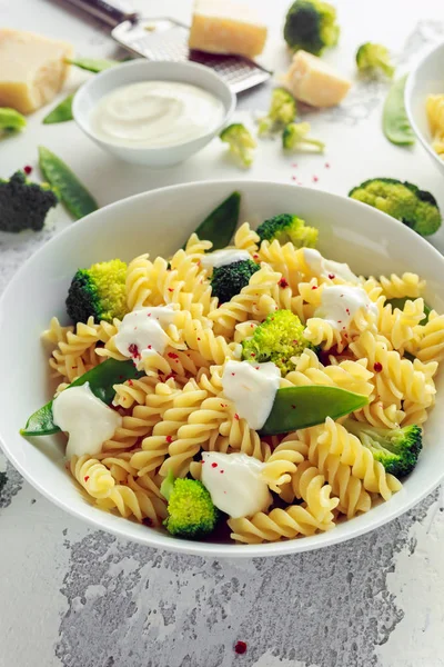 Pasta med gröna grönsaker broccoli, Mange tout och gräddig sås i vit platta — Stockfoto