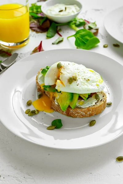 Sandviç, tost avokado, yumuşak peynir ve beyaz zemin üzerine haşlanmış yumurta — Stok fotoğraf